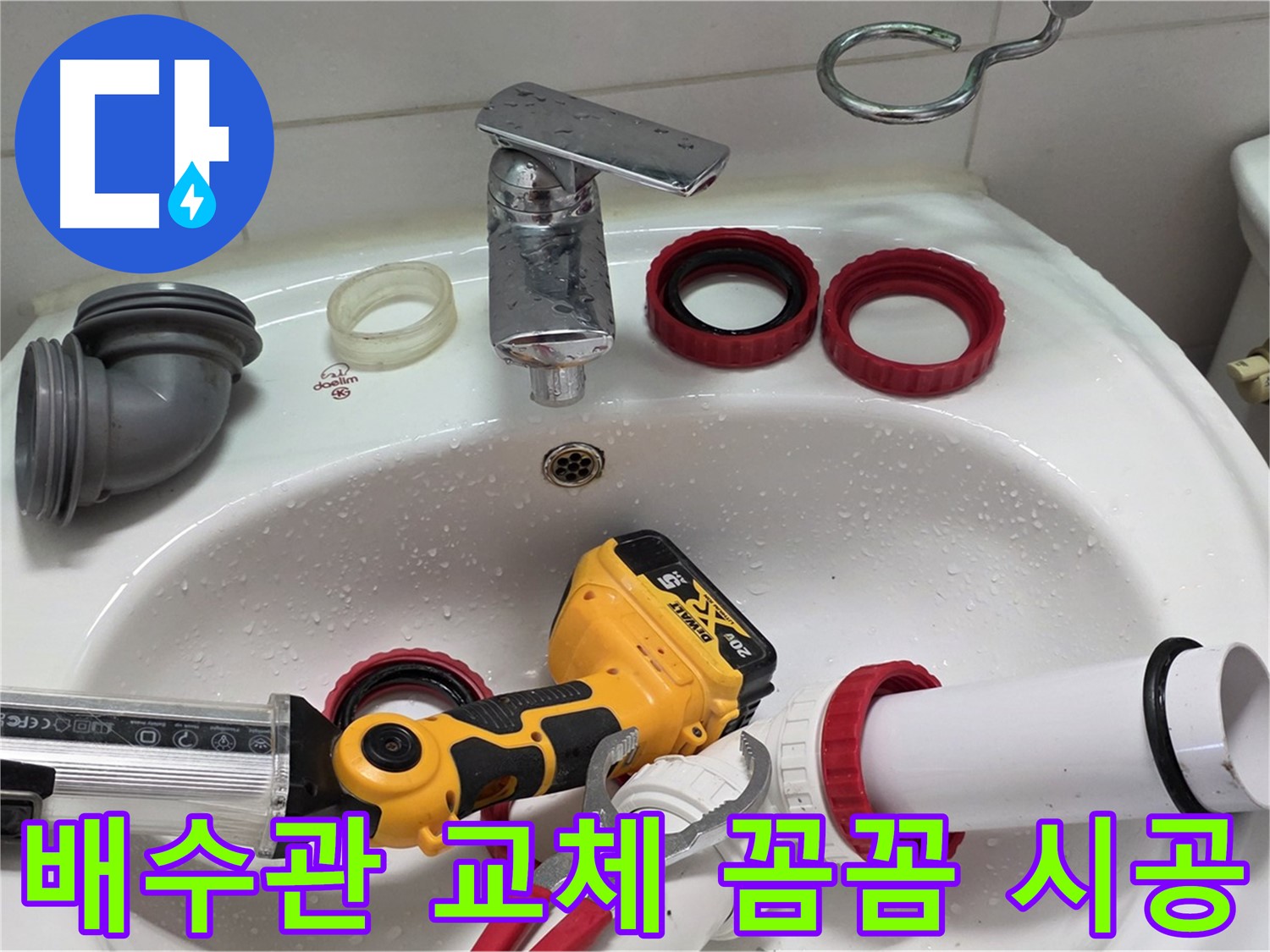 세면대 위에 놓인 은색 수전과 빨간 패킹 및 실란트 건