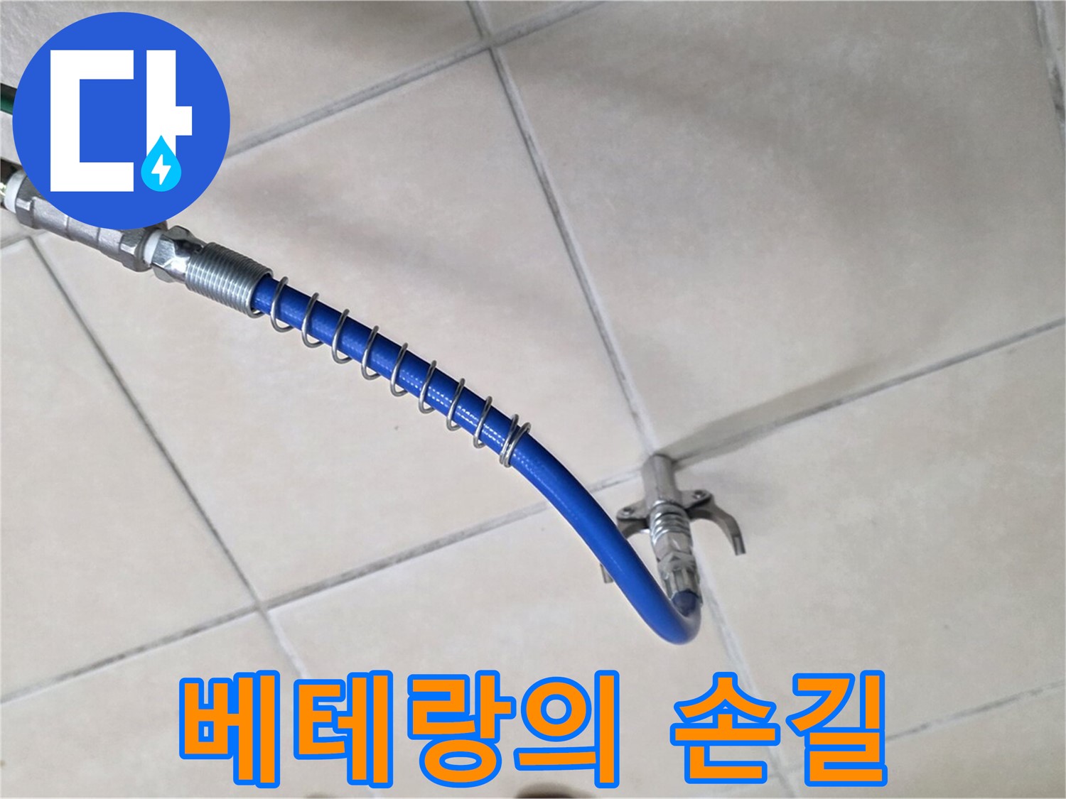 화장실 타일 바닥에 놓인 파란색 점검용 호스와 연결 부품