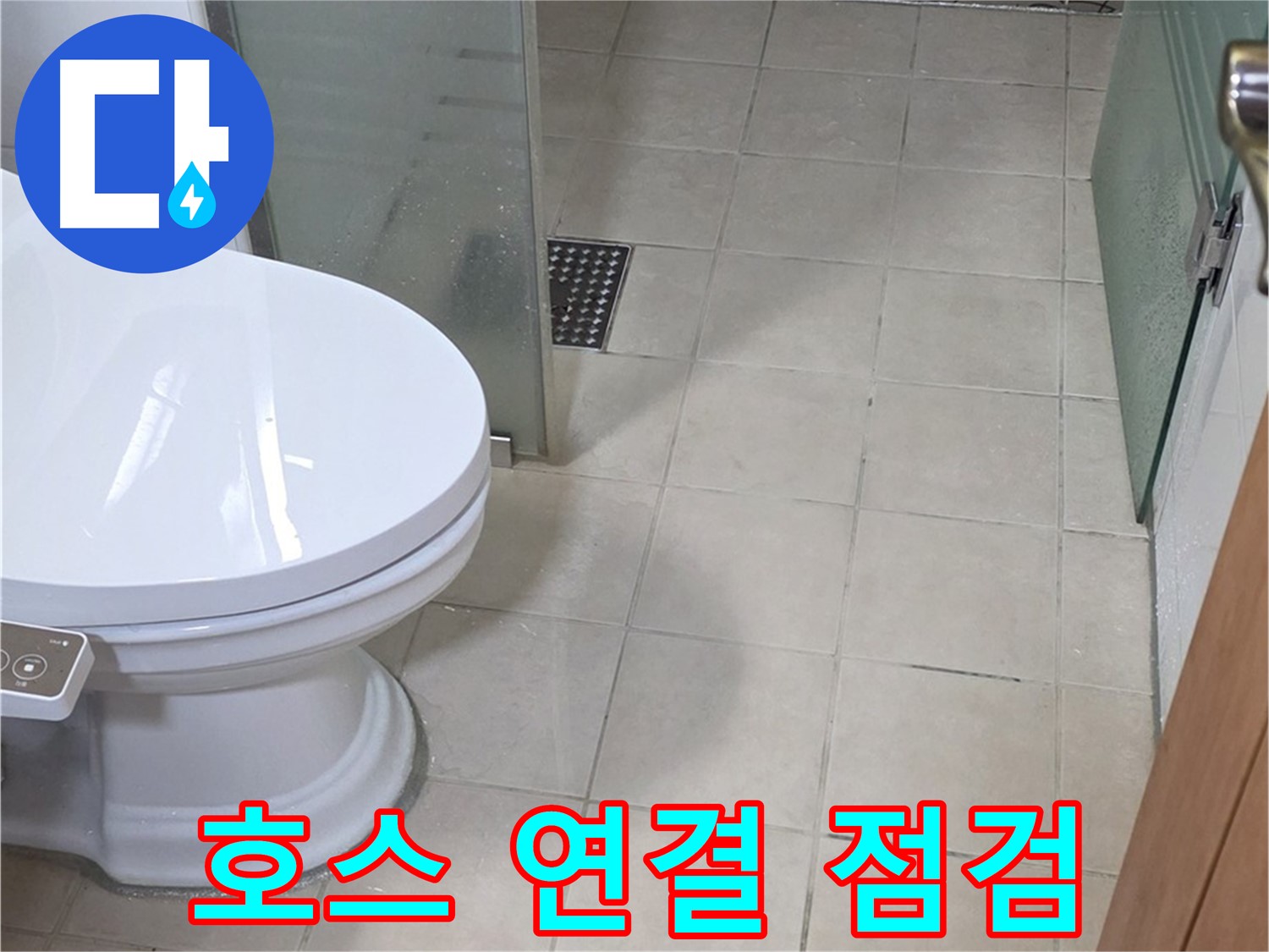 화장실 바닥의 흰색 양변기와 베이지색 타일이 보입니다.