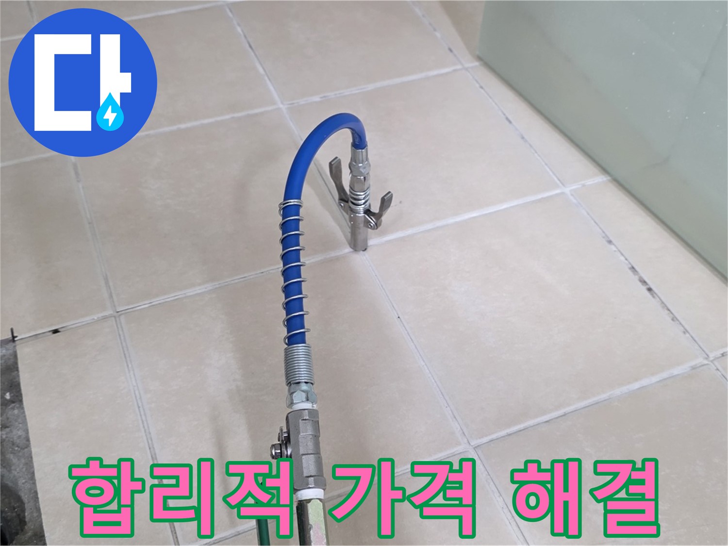 파란색 호스 장비가 연결된 화장실 바닥의 배수구 근처 모습