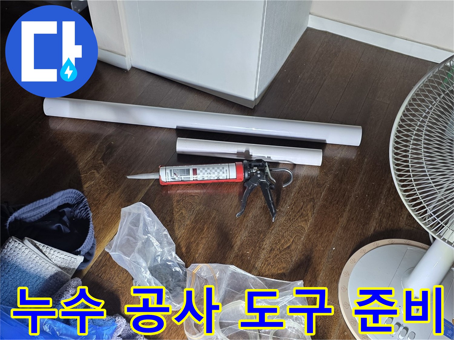 누수 공사를 위한 도구 준비 - 실리콘 건과 다양한 배관 자재들이 준비되어 있습니다.