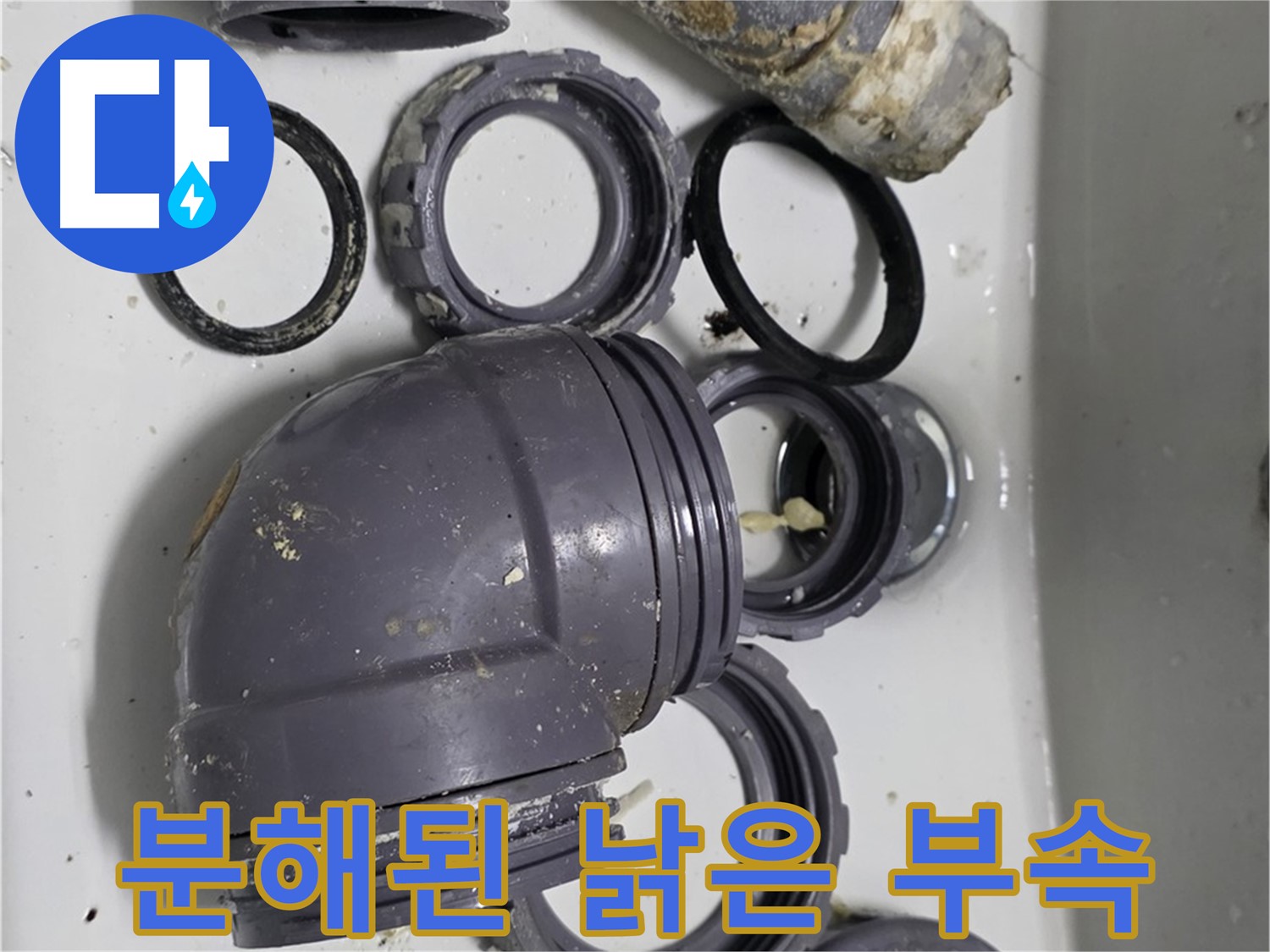 분해된 낡은 부속 - 낡고 손상된 싱크대 부속들이 분해되어 버려질 준비를 하고 있습니다.