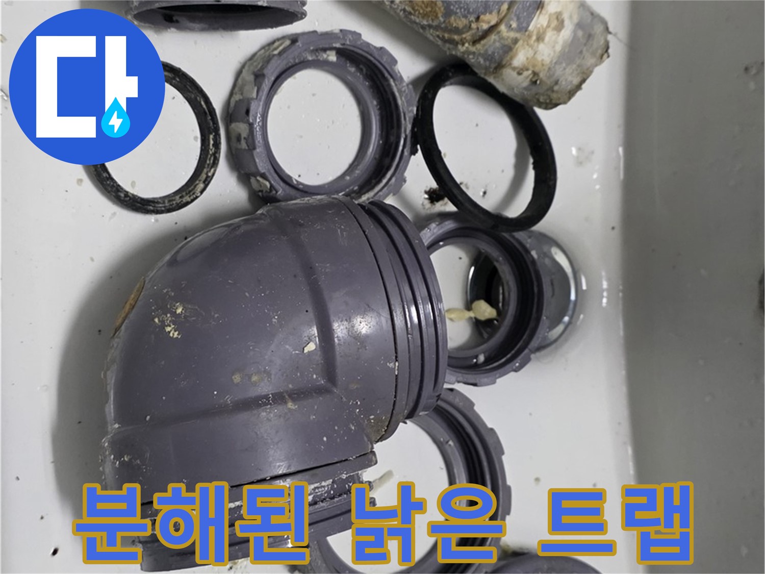 분해된 낡은 트랩 - 낡고 손상된 싱크대 트랩 부품들이 분해되어 있습니다.