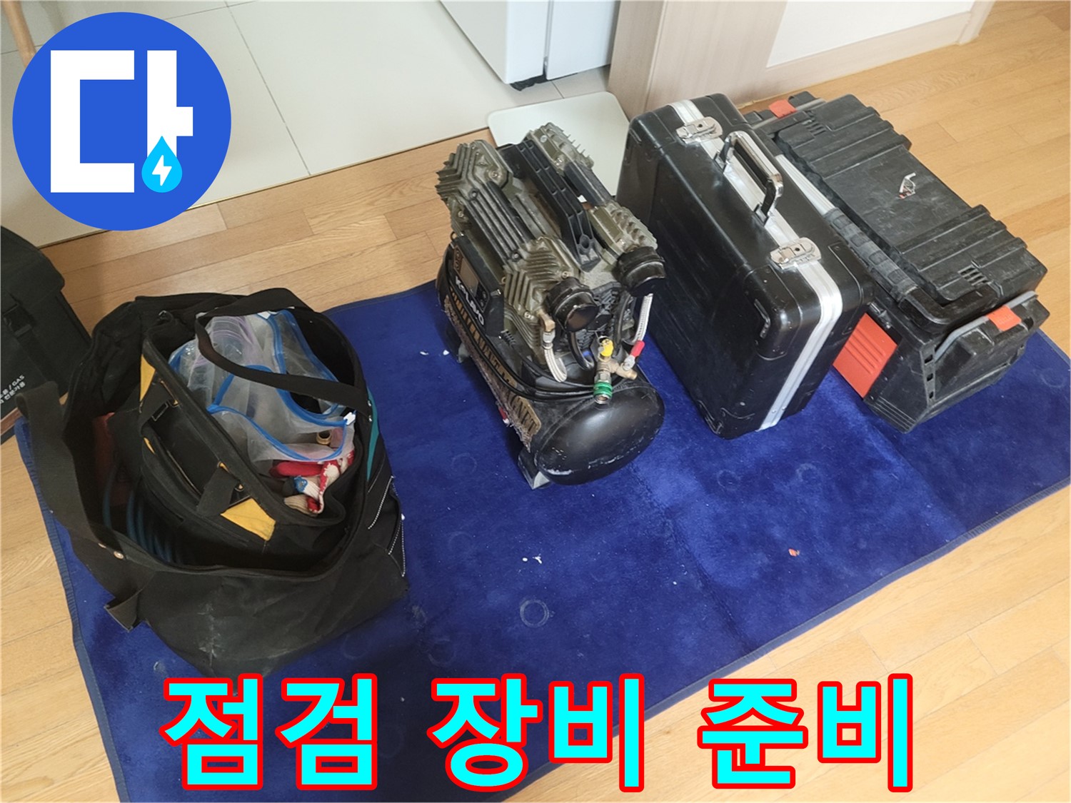 누수 점검을 위한 장비 준비 - 콤프레셔, 공구 가방, 장비 케이스가 꼼꼼한 점검을 위해 준비되었습니다.
