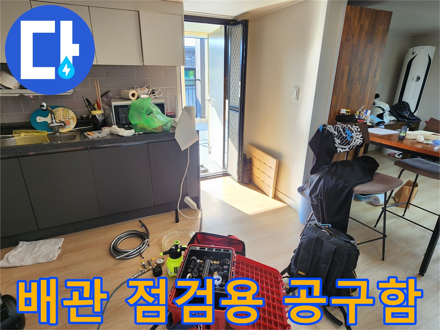 바닥에 놓인 빨간색 케이스의 누수 탐지 장비와 각종 수리 부속품들