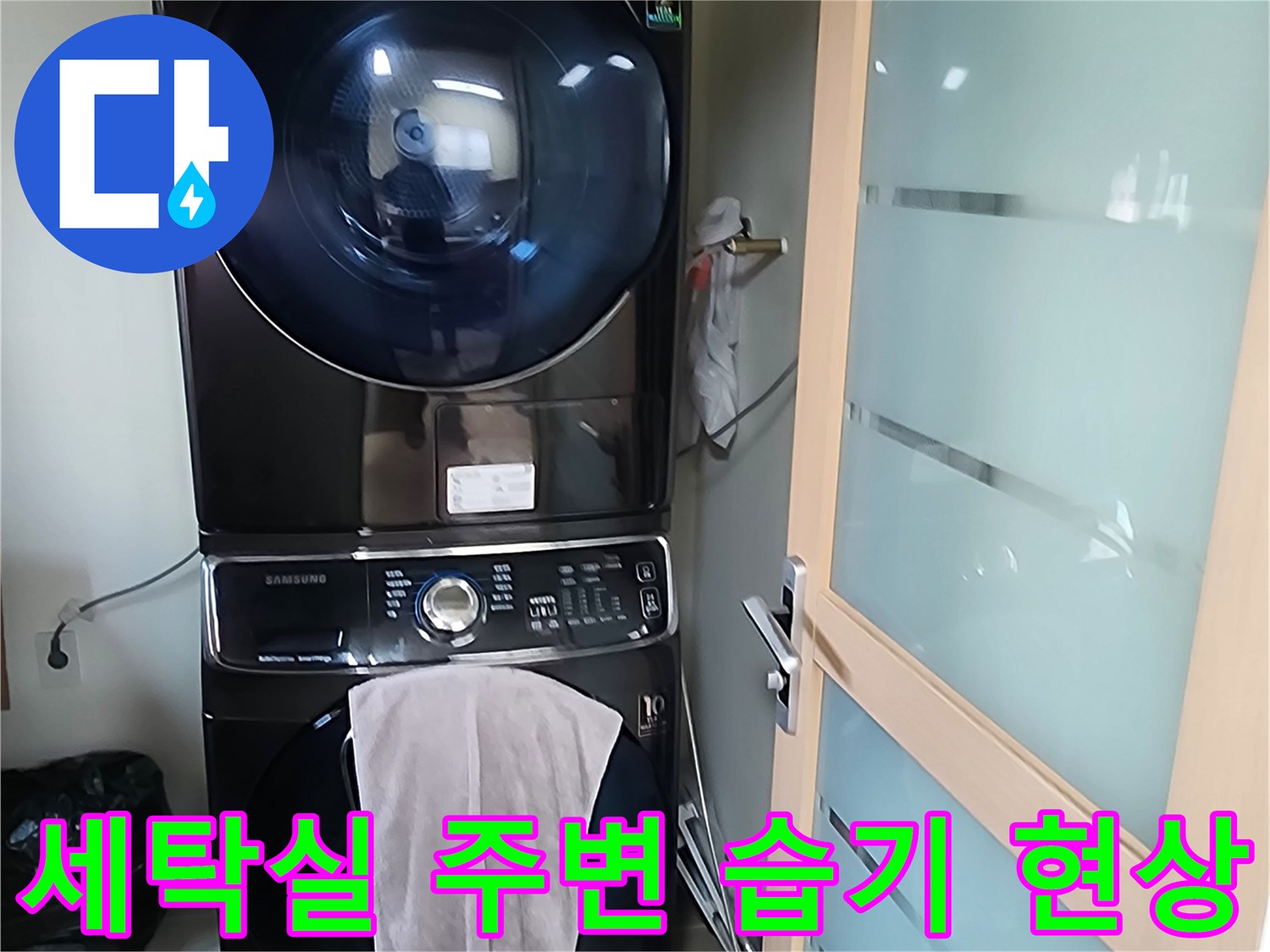 세탁기와 건조기가 설치된 세탁실 벽면의 습기 상태를 확인하는 모습