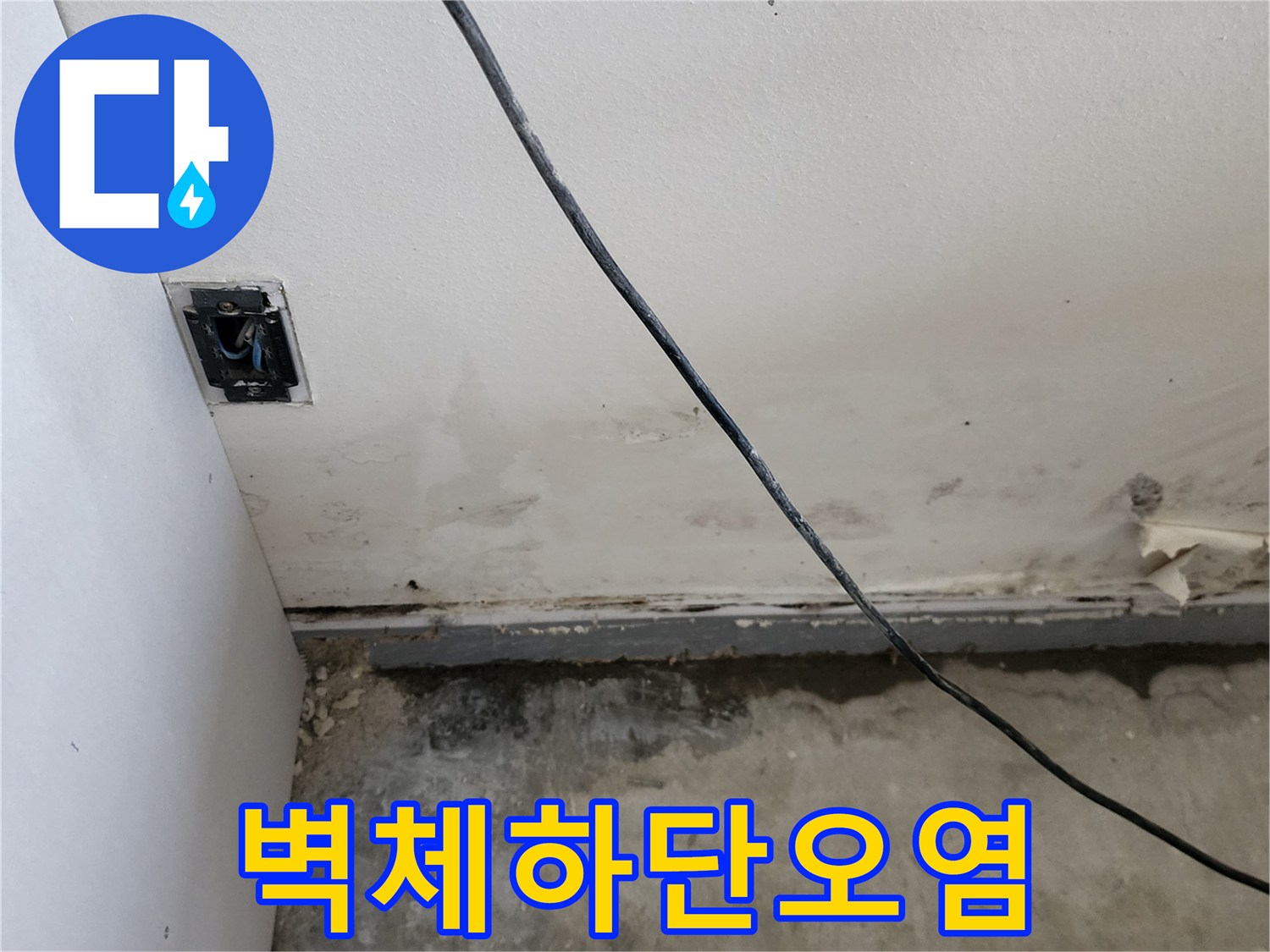 누수로 인해 변색된 벽면 하단부와 노출된 전기 배선 근처의 상태