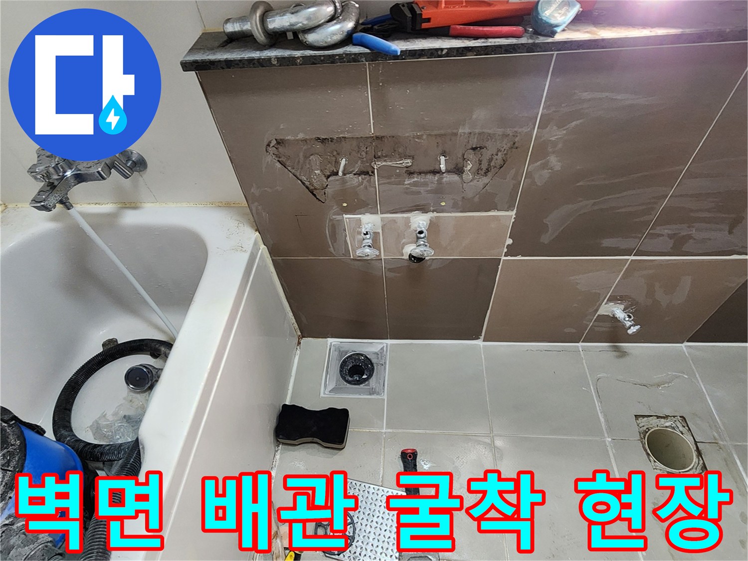 양주2동 욕실-타일 제거 후 노출된 수도 배관과 작업 도구들