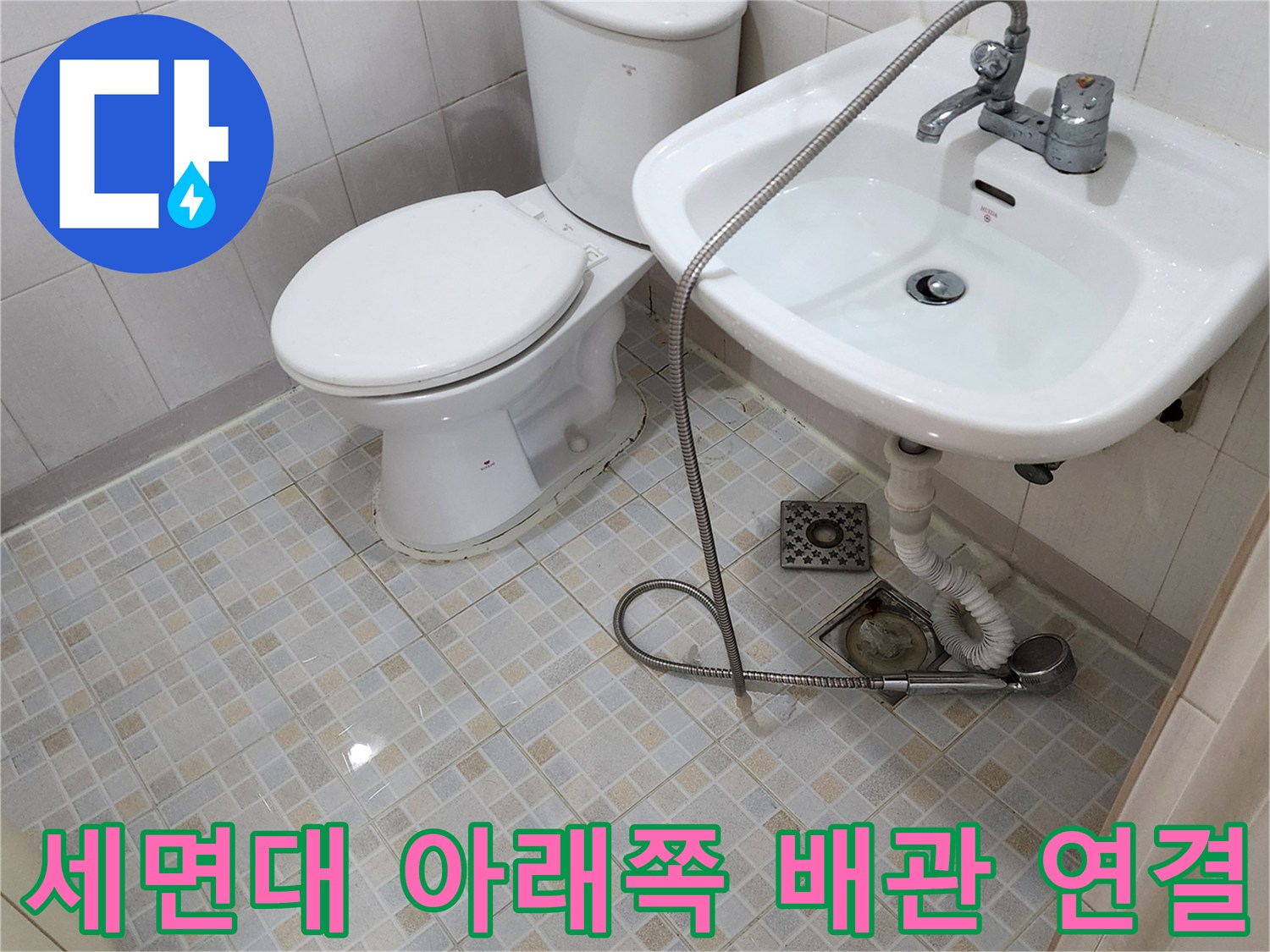 세면대 하단 수전 호스와 바닥 배수구 주변의 모습입니다.