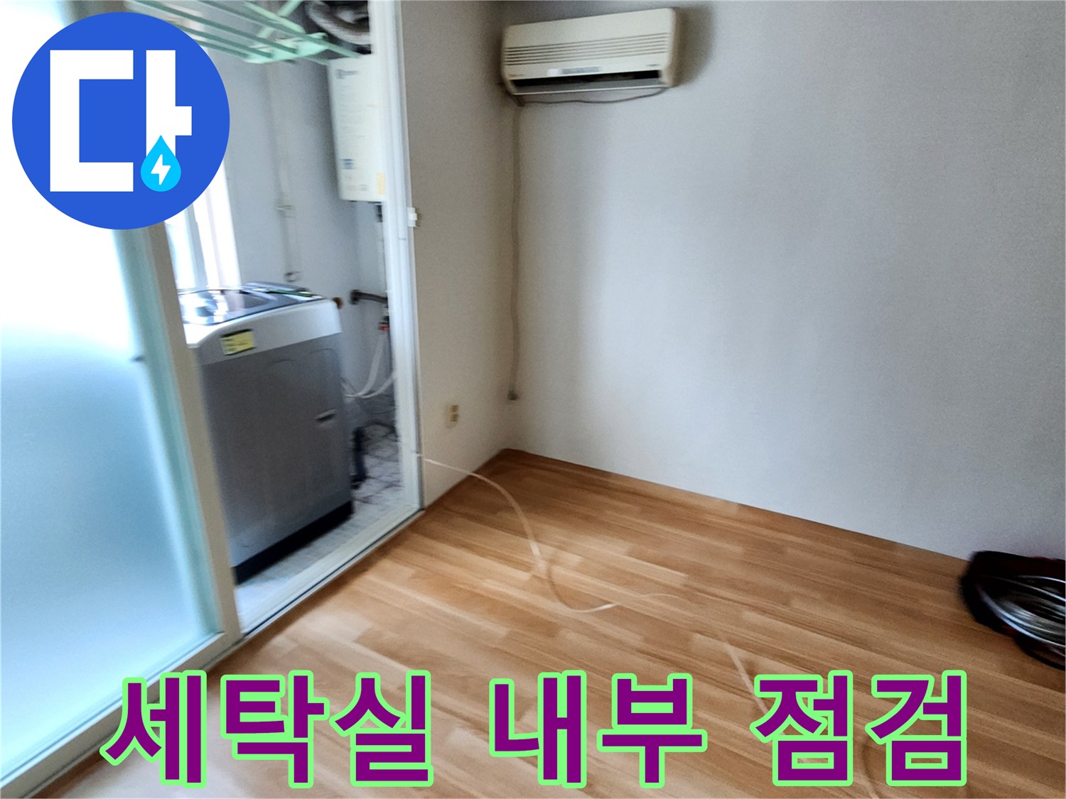 세탁기 옆 다용도실 벽면과 에어컨 실내기가 설치된 공간의 모습입니다.