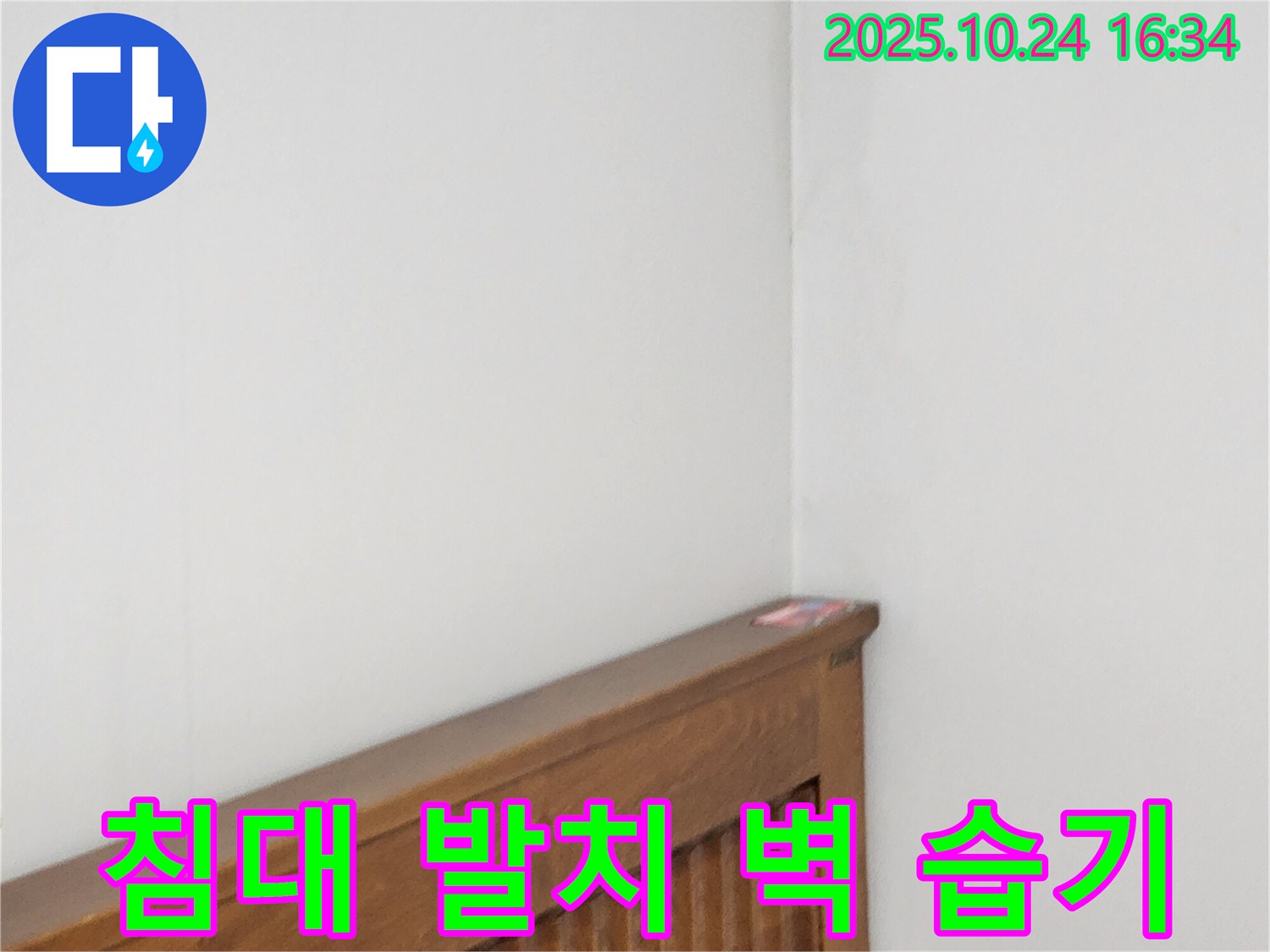 양주1동 봉우로 누수 현장 - 침대 발치 벽 누수로 인한 습기를 제거하는 누수 전문가의 습기 제거 작업