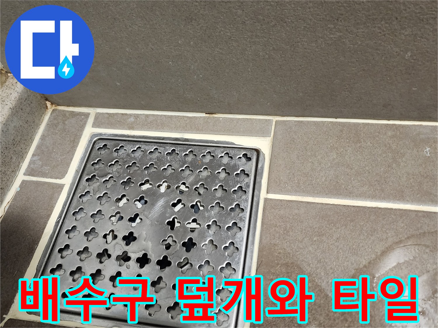 금속 재질의 배수구 덮개와 주변 타일 마감 부위