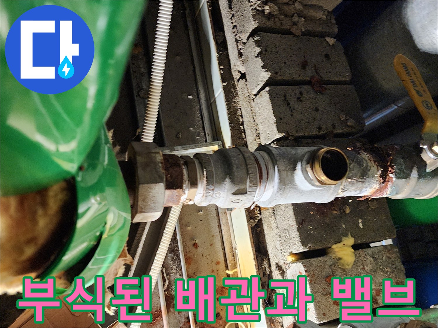 부식이 진행된 금속 배관-및 연결 부위의 누수 흔적을 보여주는 현장 사진입니다.
