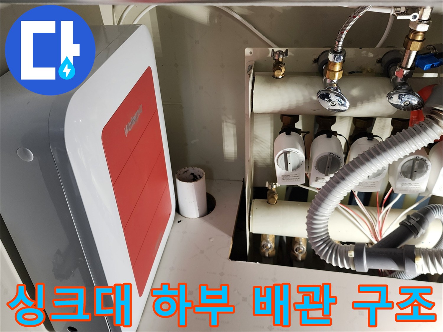 싱크대 아래쪽 급수 밸브와 호스 연결 부위의 모습