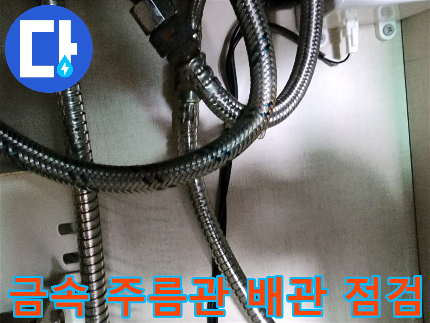 싱크대 하단-얽혀 있는 금속 주름관의 연결 부위 근접 촬영