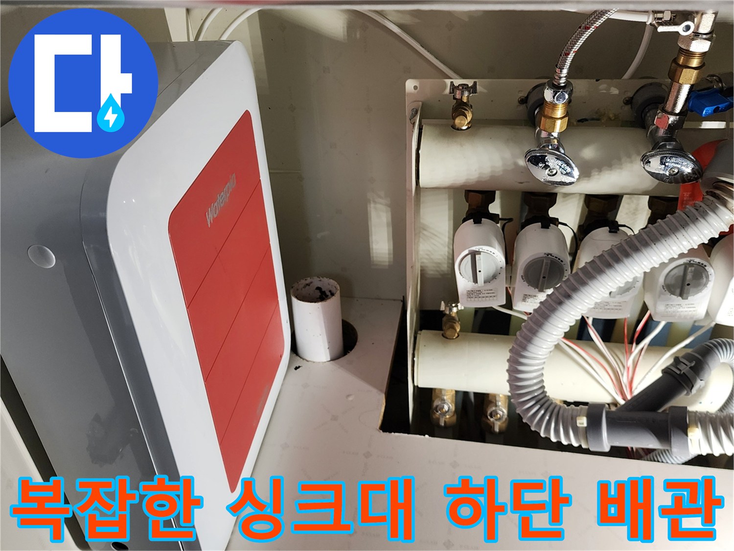 싱크대 하부장 내부의 급수 밸브와 배수 호스 구조