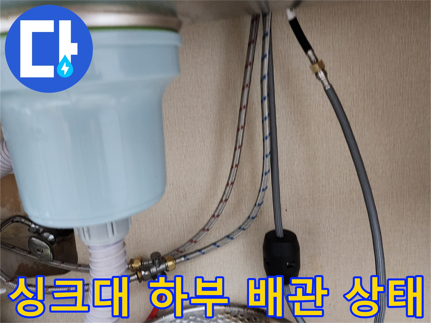 주방 싱크대 아래쪽의 급수 및 배수 배관 연결 부위 모습