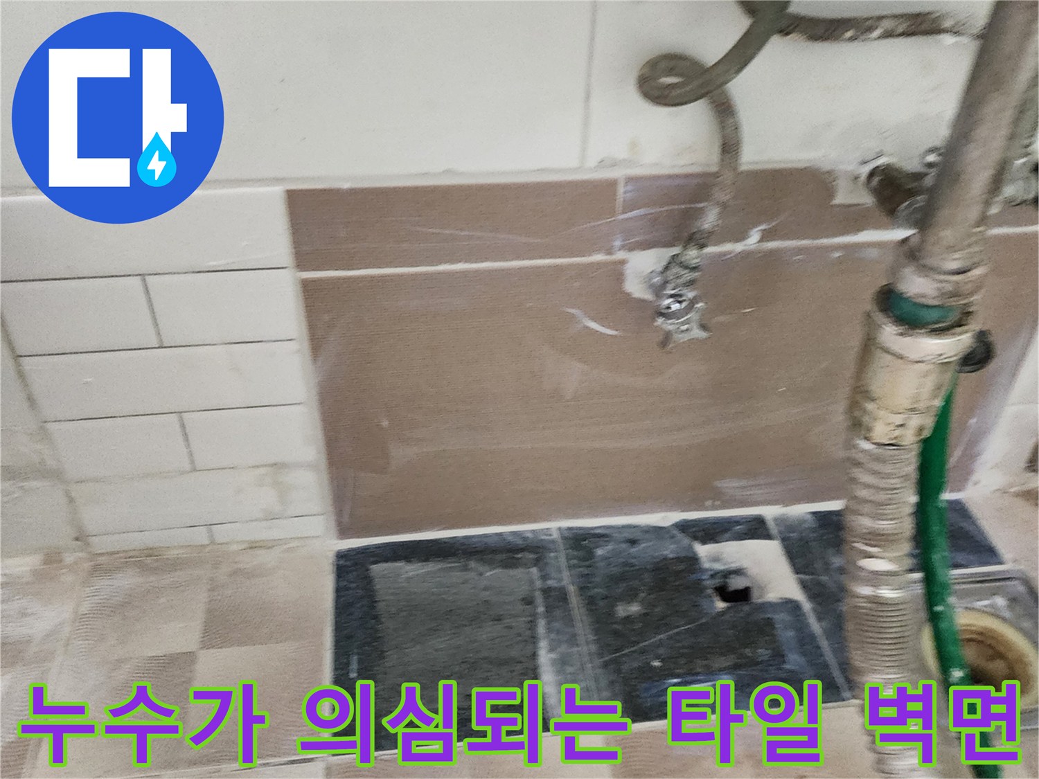 물기가 스며든 세탁실 벽면 타일과 노출된 급수 호스