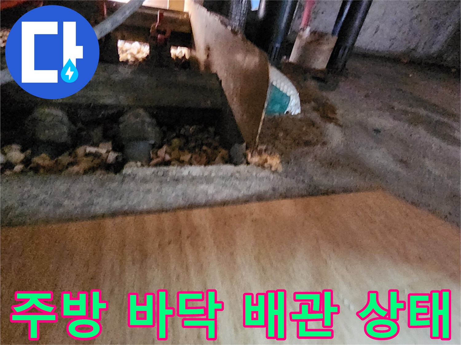 주방 하부장 아래 배관과 주변 자재의 습기 상태를 보여주는 사진입니다.