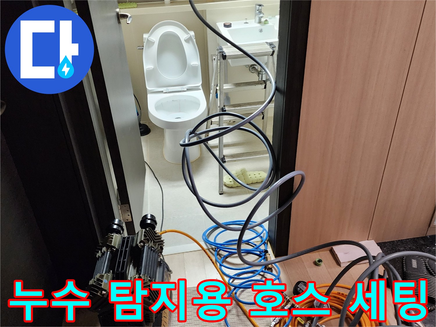 욕실 입구에 설치된 - 누수 진단용 - 압력 테스트 장비와 호스들