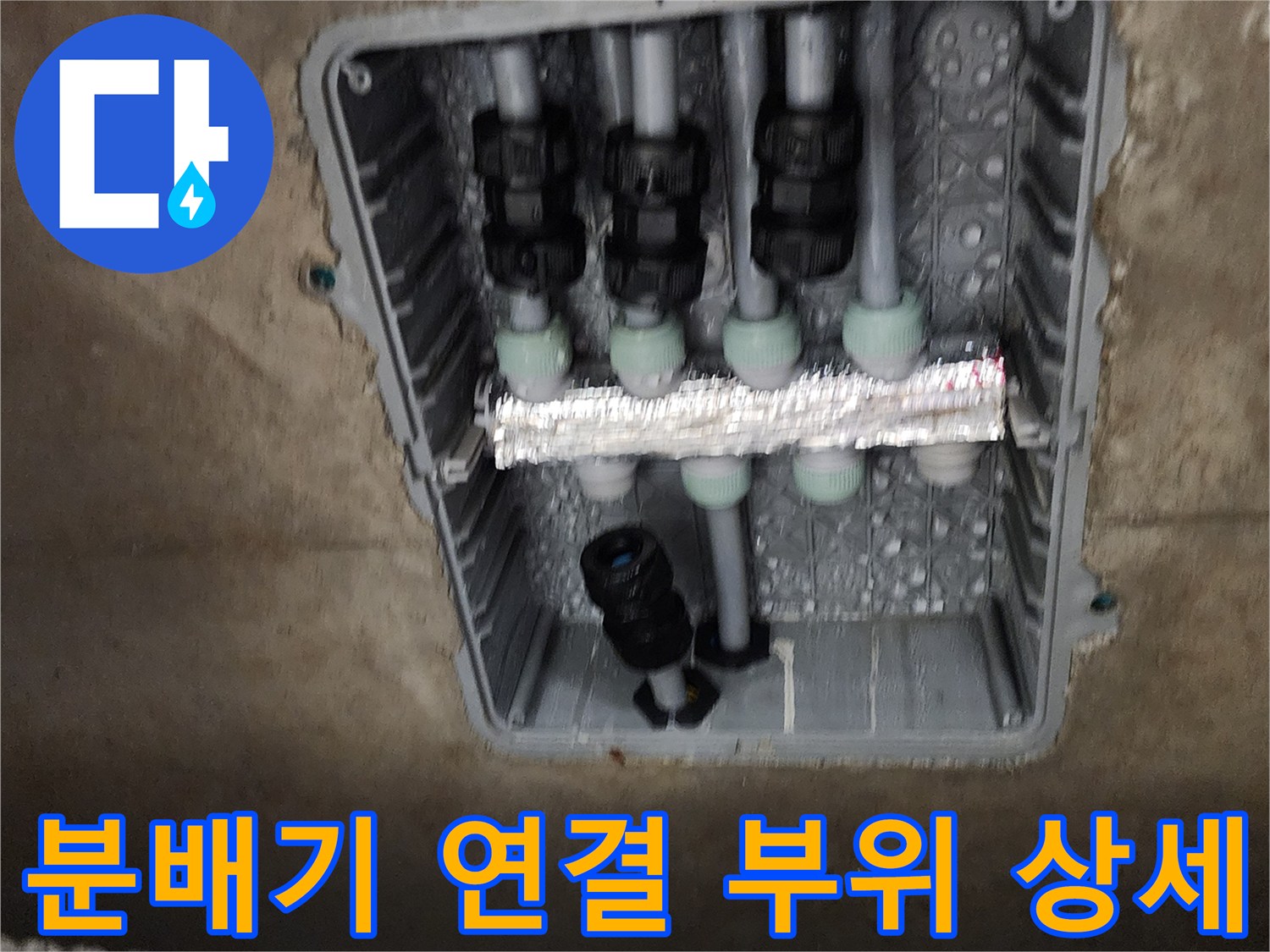 매립된 배관함 내부의 분배기 밸브와 연결 소켓 근접 촬영