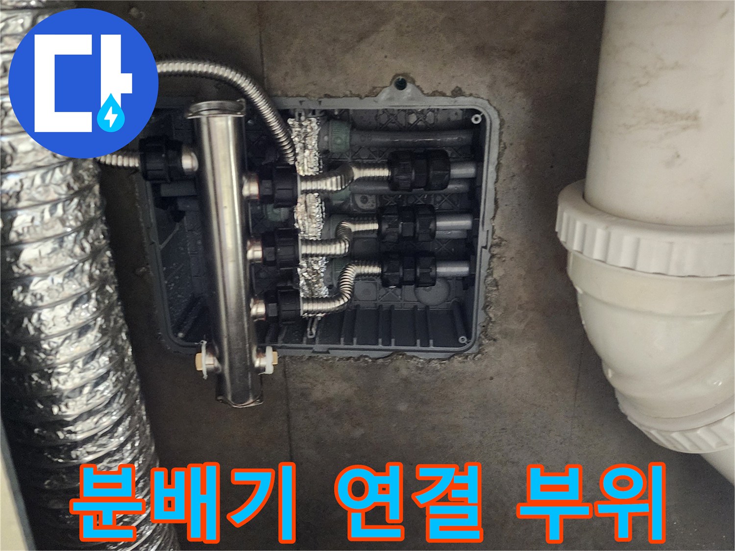 스테인리스 관과 검은색 유니온이 연결된 분배기 구조