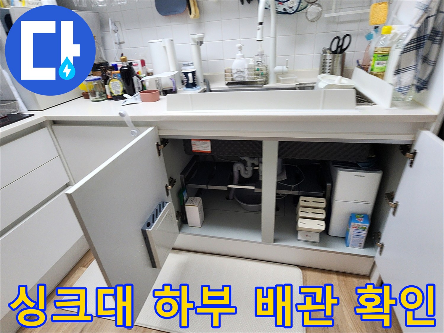싱크대 아래쪽 배관 및 매립함 부위를 점검하기 위해 개방된 상태입니다.