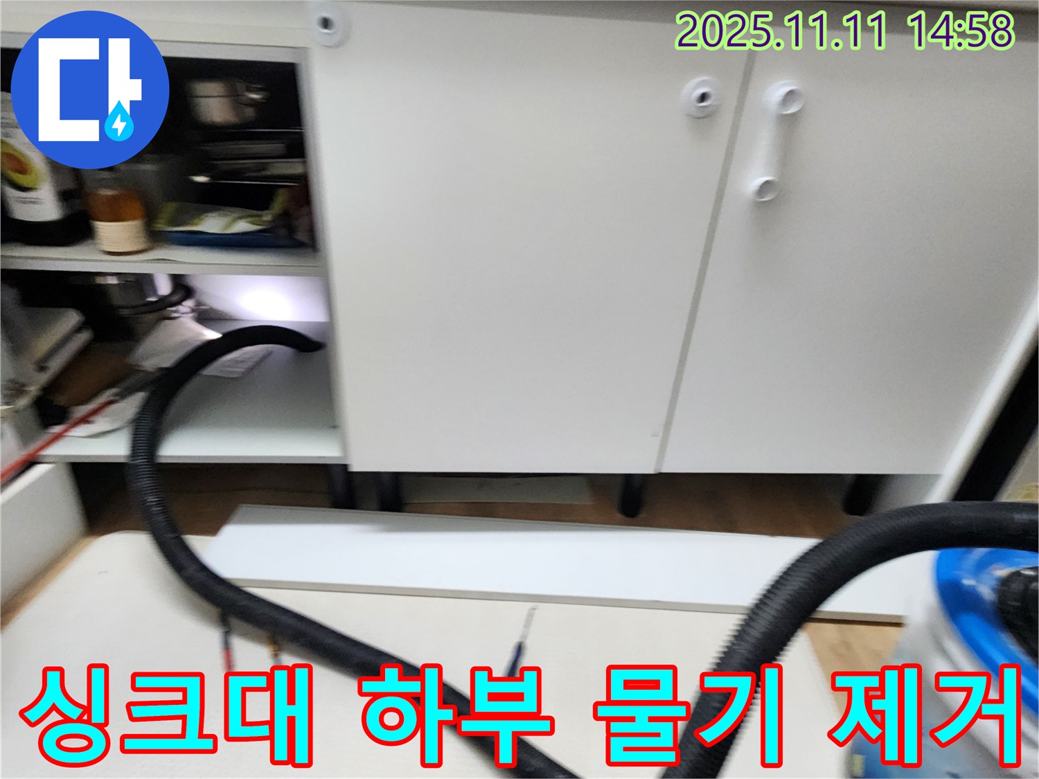 싱크대 하부 물기 제거 - 누수 후 남은 물기를 흡입기로 꼼꼼하게 제거하고 있습니다.