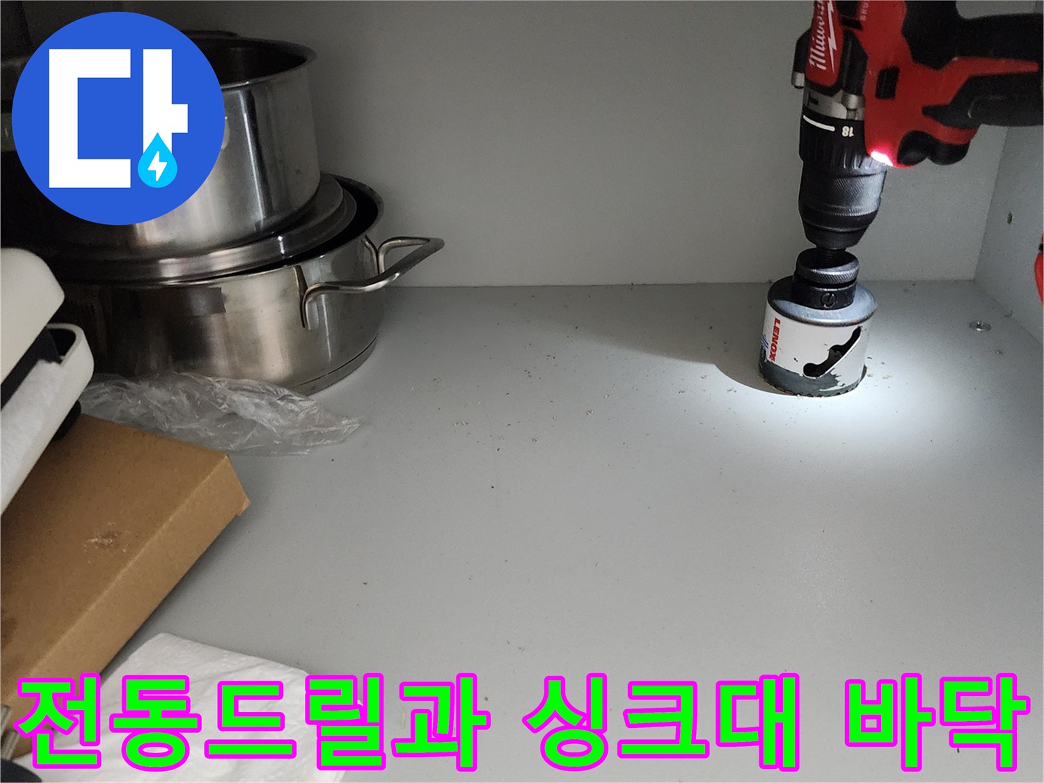 싱크대 하부장 내부-전동 드릴을 이용한 점검 중인 모습