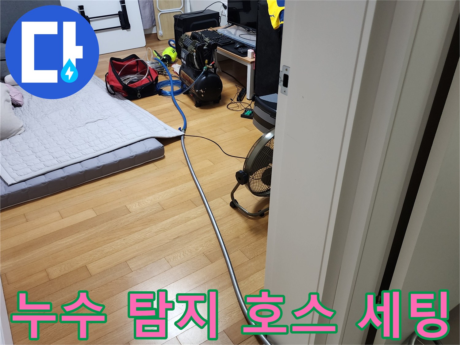 거실 바닥에 배치된 누수 진단용 에어 호스와 장비들