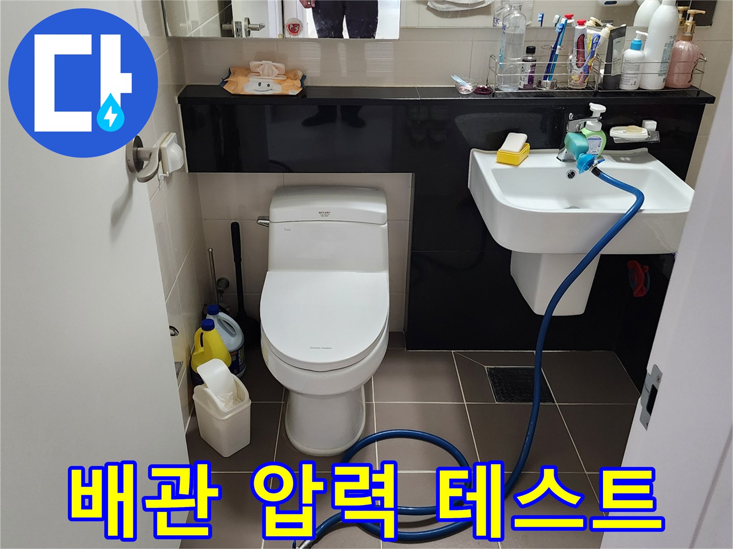 세면대 하부 배관에 연결된 파란색 공압 테스트용 호스