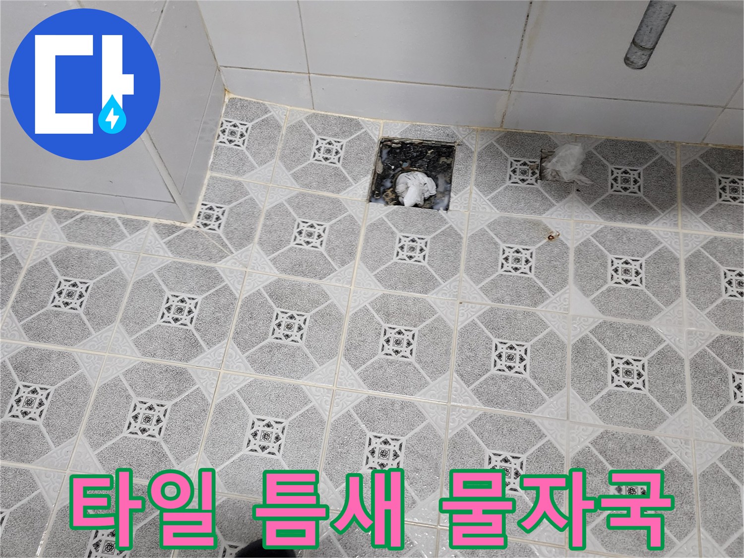 물기가 스며들어 어둡게 변한 욕실 벽면 배수구 주변부