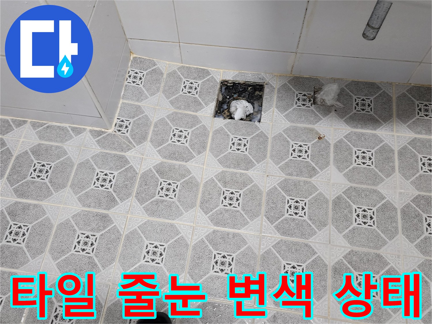 물기에 젖어 색이 변한 욕실 타일과 배수구의 모습