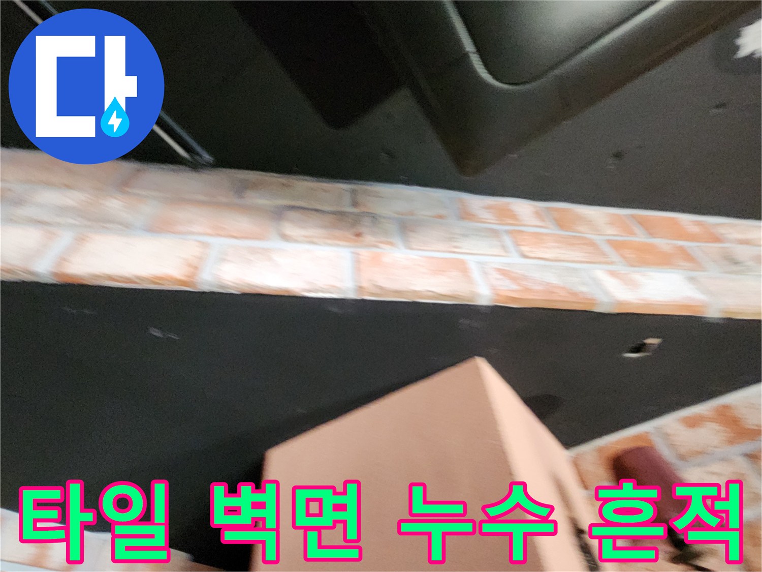 벽돌 패턴 타일에 나타난 어두운 습기 오염 부위