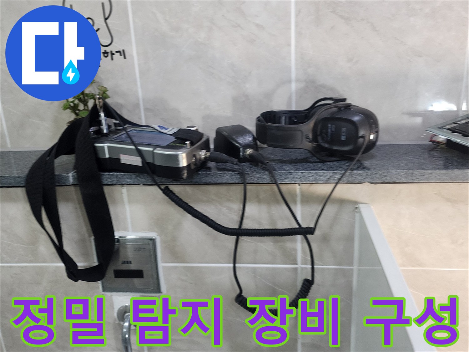 소변기 근처 타일 선반에 놓여 있는 배관 청음용 장비들
