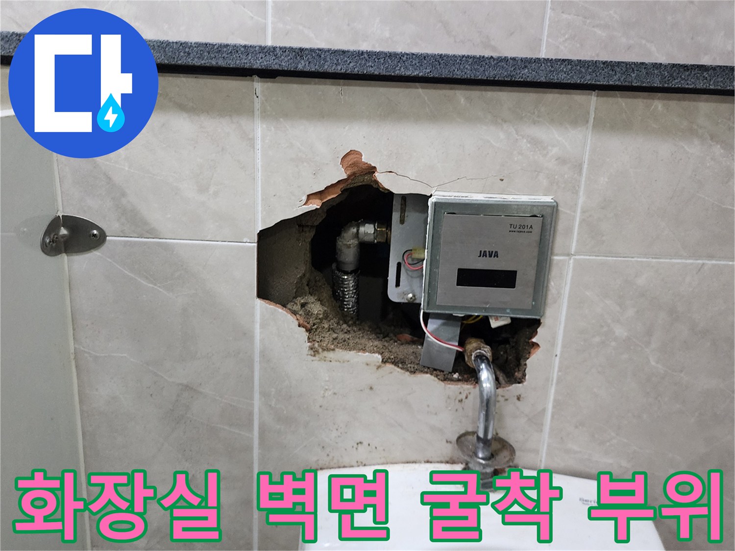 소변기 뒤쪽 타일 벽면을 제거하여 내부 배관과 자동 밸브를 노출시킨 장면