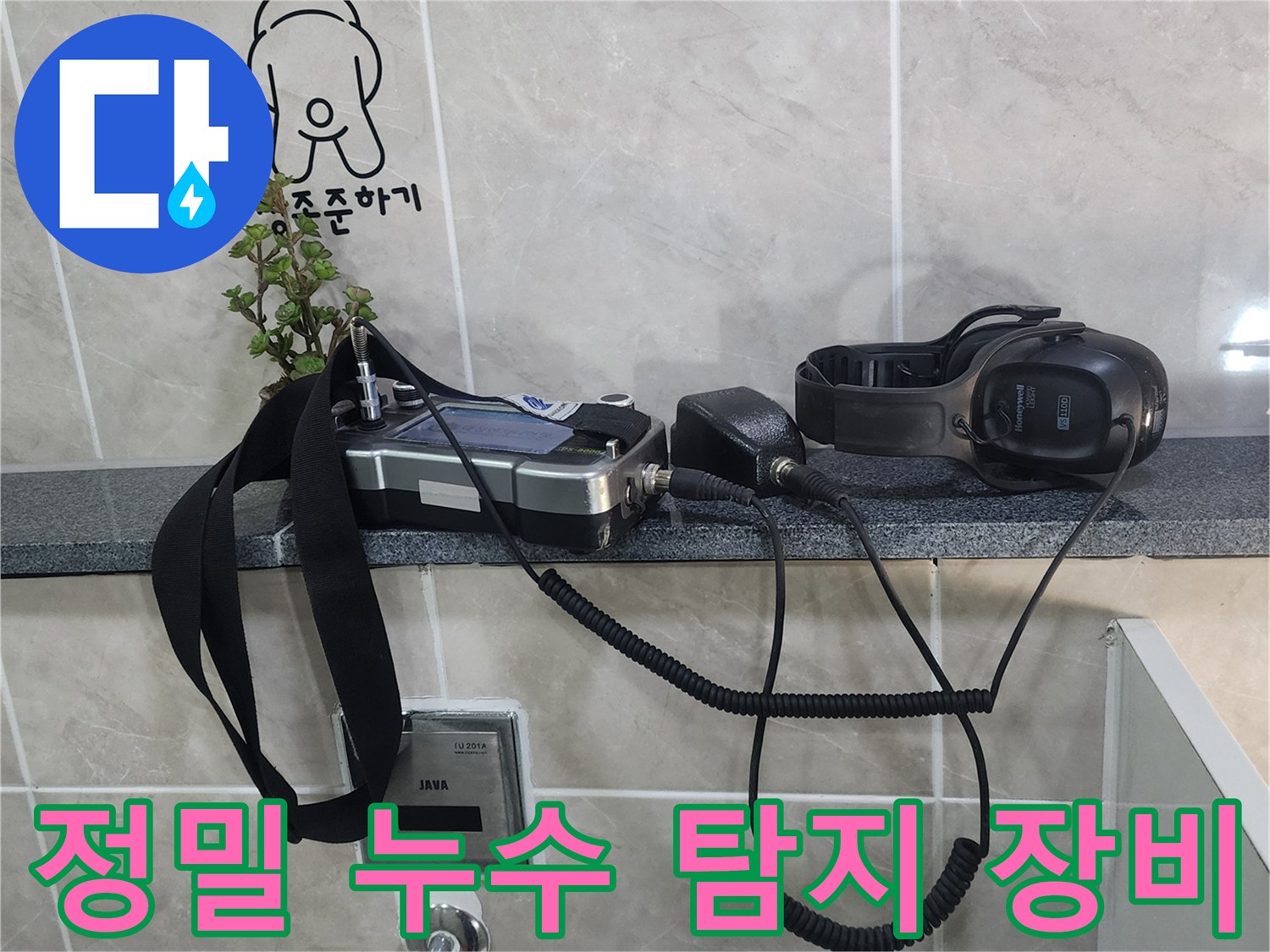 화장실 벽면 선반 위에 놓인 청음식 누수 탐지기와 수신기
