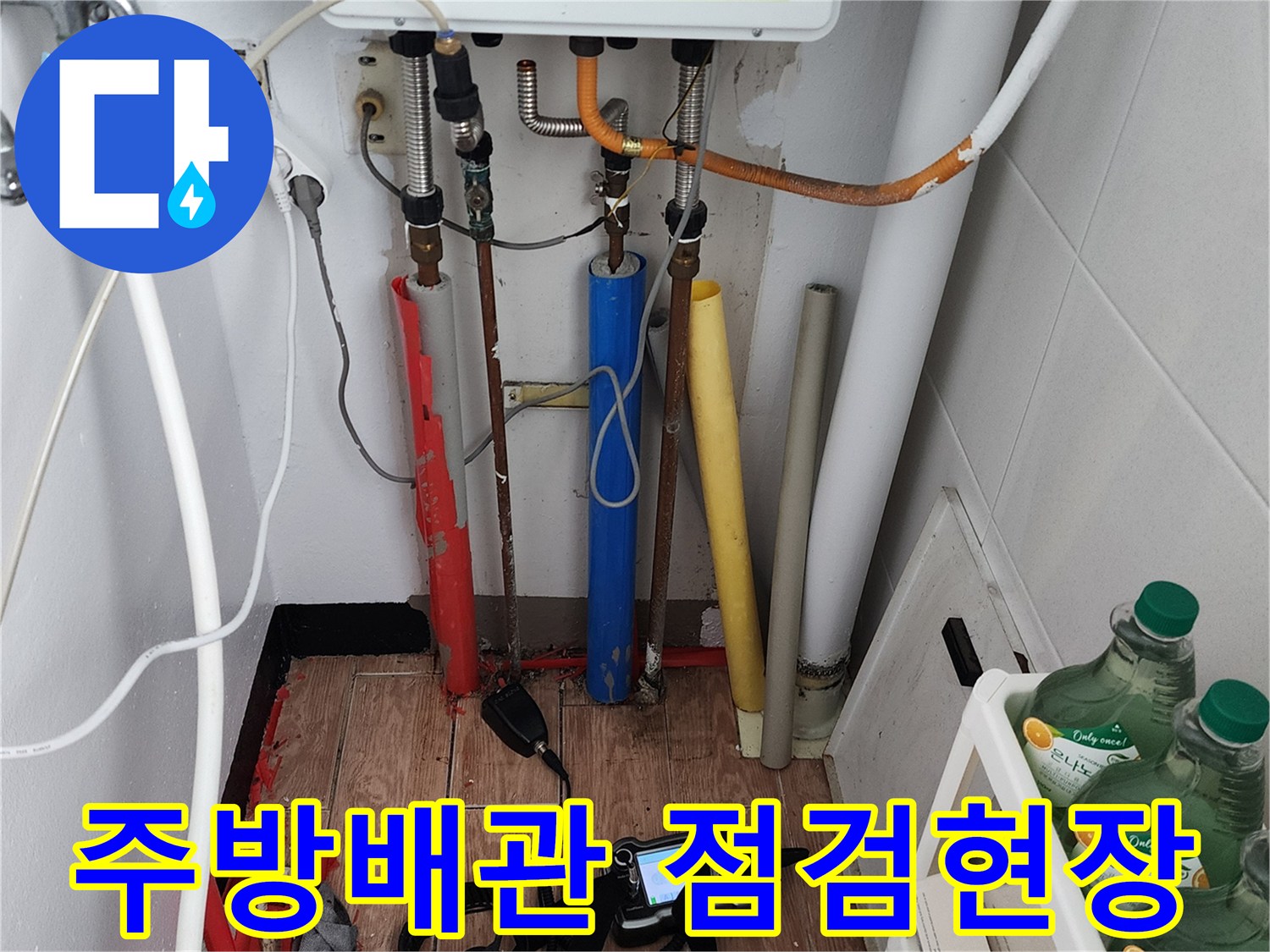 보일러 하부 배관의 연결 부위와 탐지 장비가 놓여 있는 모습
