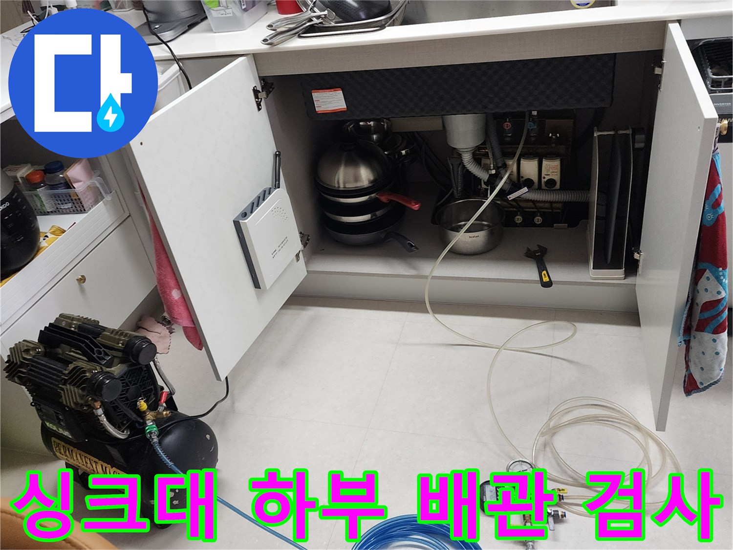 싱크대 아래 배관 구조-누수 지점을 찾기 위해 장비를 연결하여 압력 테스트를 실시합니다.