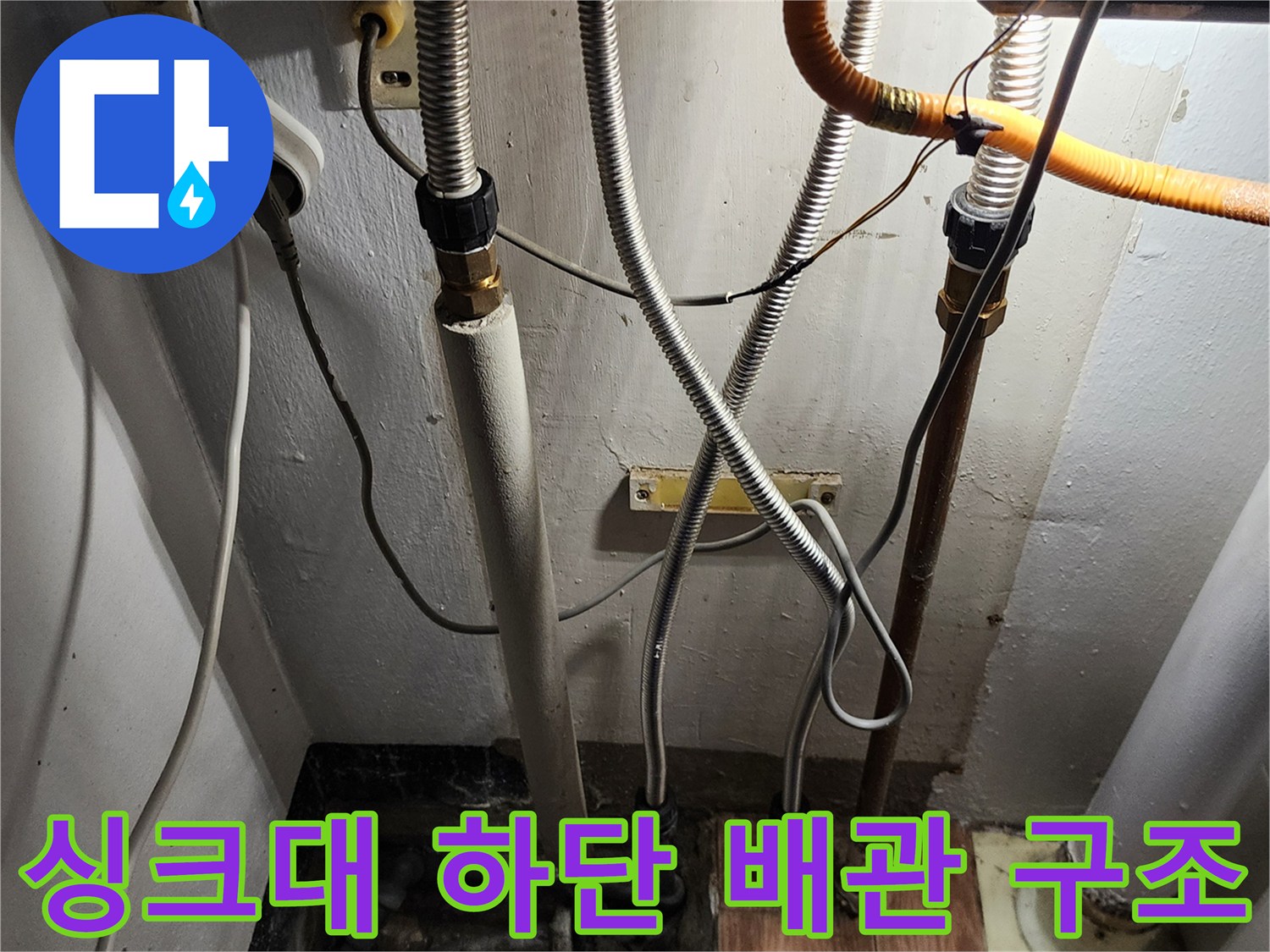 싱크대 아래쪽의 다양한 배관 연결 상태와 노후 부위를 촬영한 사진입니다.