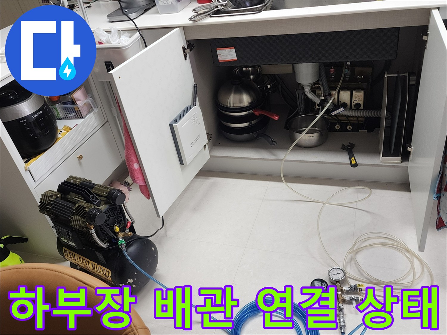 싱크대 하단 배관과 압력 조절기 및 공기 호스 배치 모습