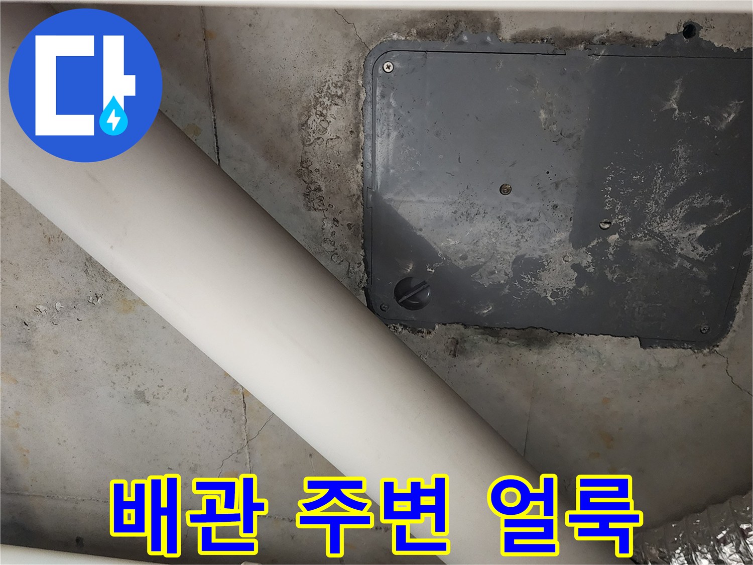 배관 주위의 젖은 벽면과 점검구 상태를 보여주는 사진입니다.