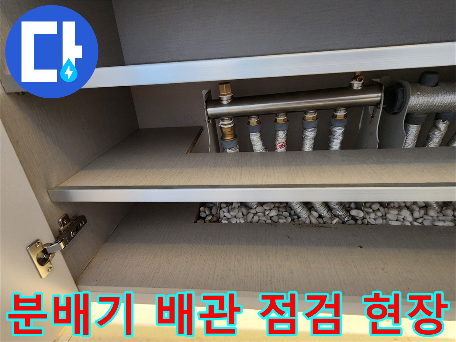 분배기 하단의 보온재 처리된 배관과 자갈층 근접 촬영 사진입니다.