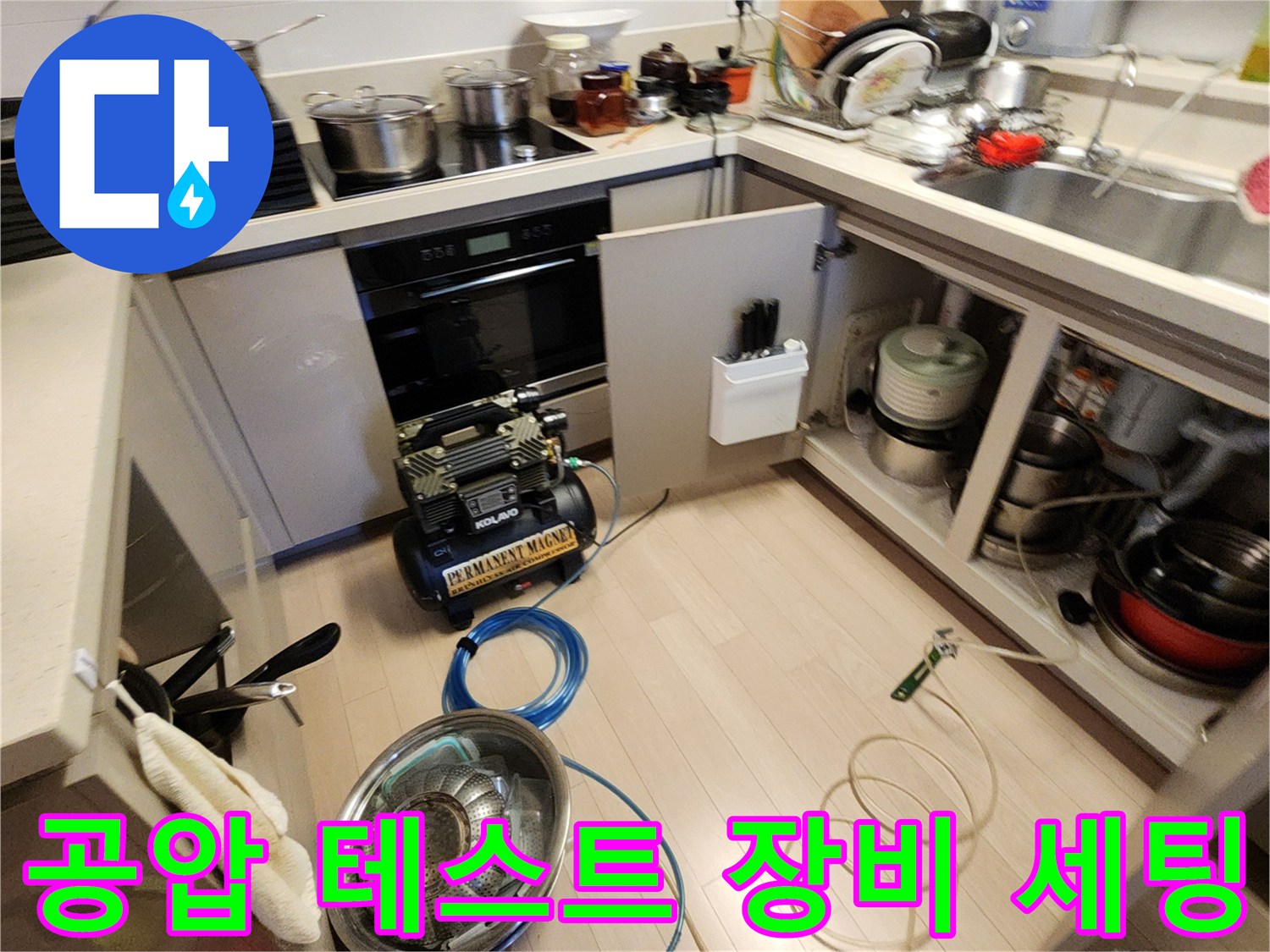 싱크대 아래 공간에서 진행 중인 배관 공압 측정 작업 모습