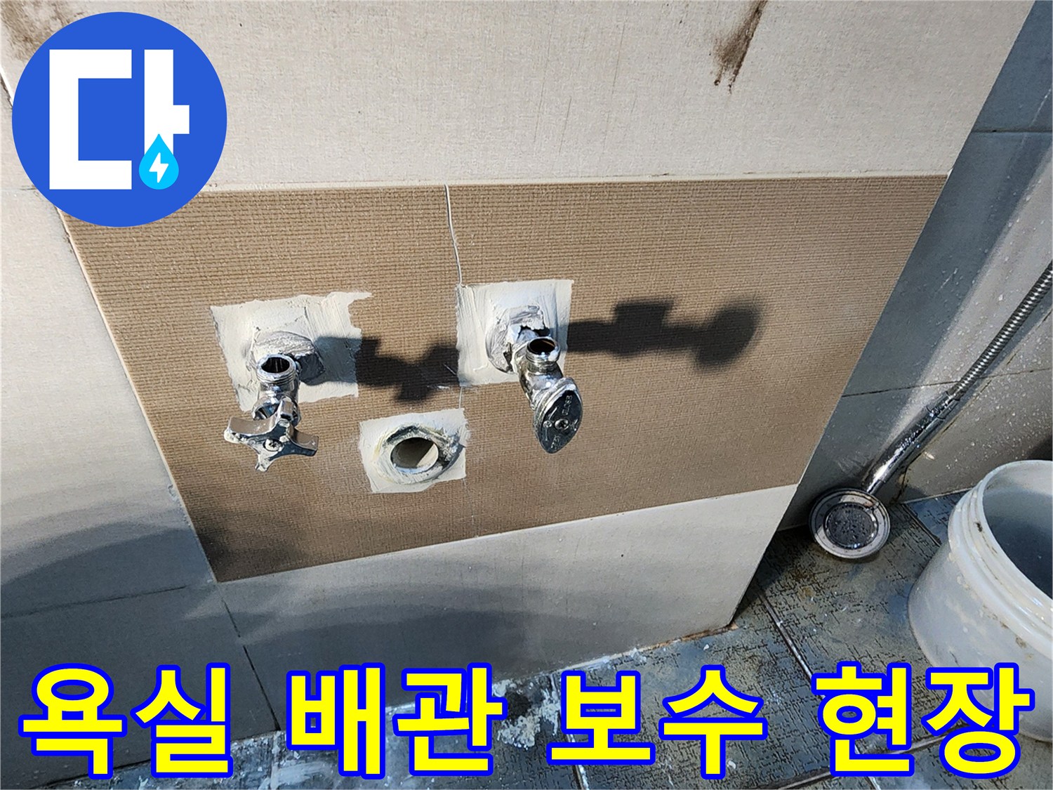 벽면 타일 사이로 노출된 수도 연결 부위와 교체용 배관