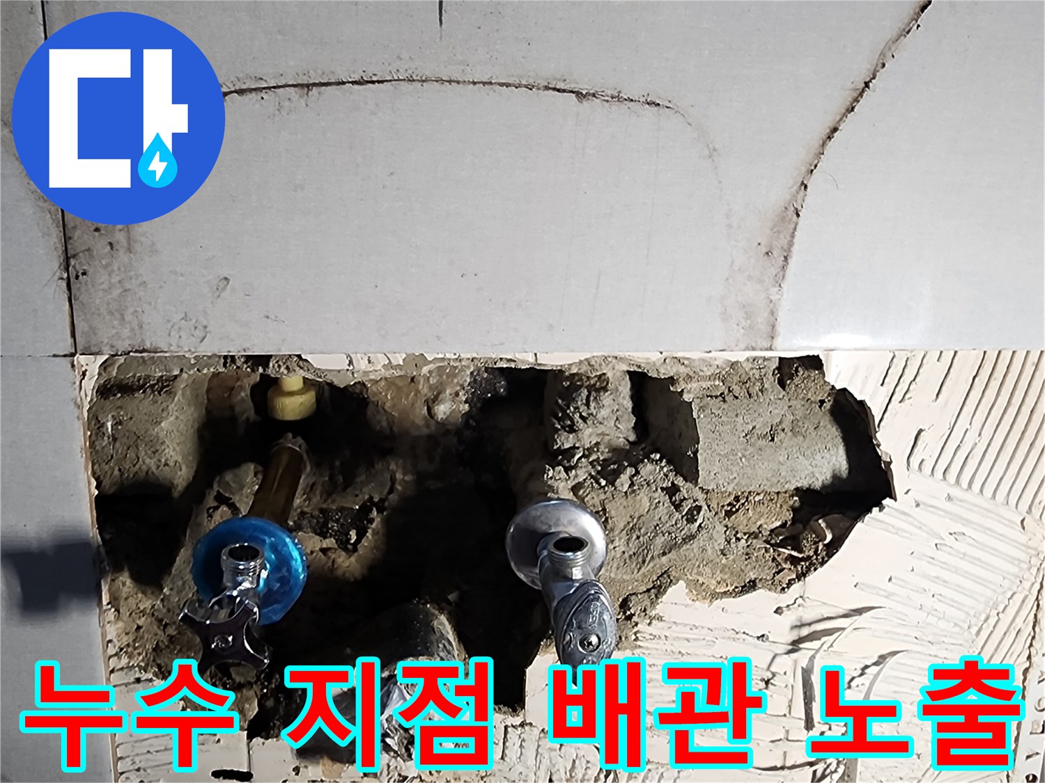 타일 제거 후 드러난 수도 배관과 젖은 벽면 내부