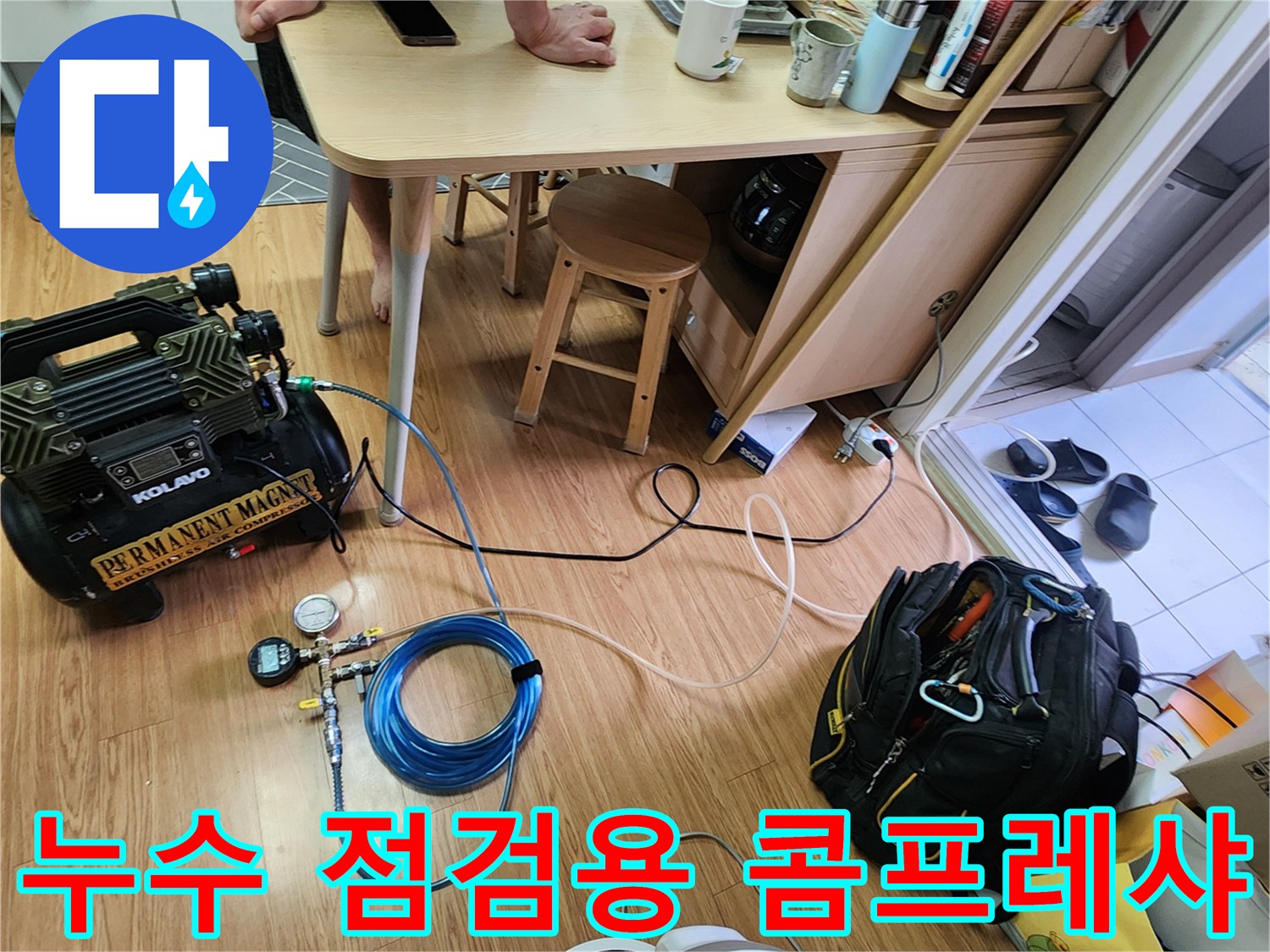 바닥에 놓인 누수 탐지용 공압 장비와 연결 호스