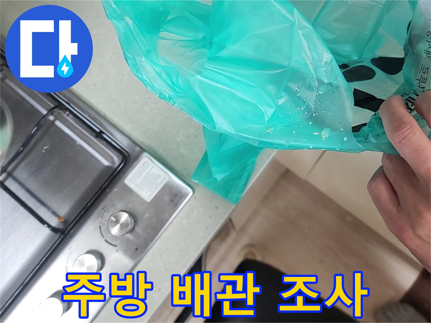 싱크대 가스레인지 옆 배관 부위를 점검하는 엔지니어의 손