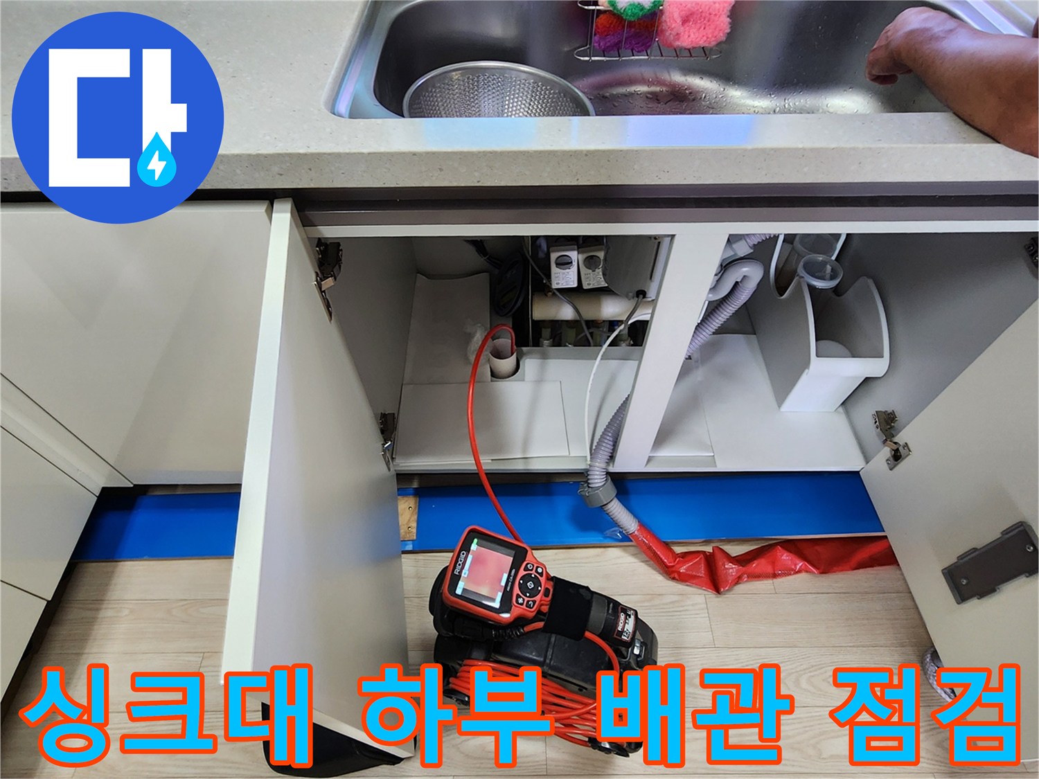 주방 싱크대 하부장 내부의 배관 상태와 탐지 장비 모습