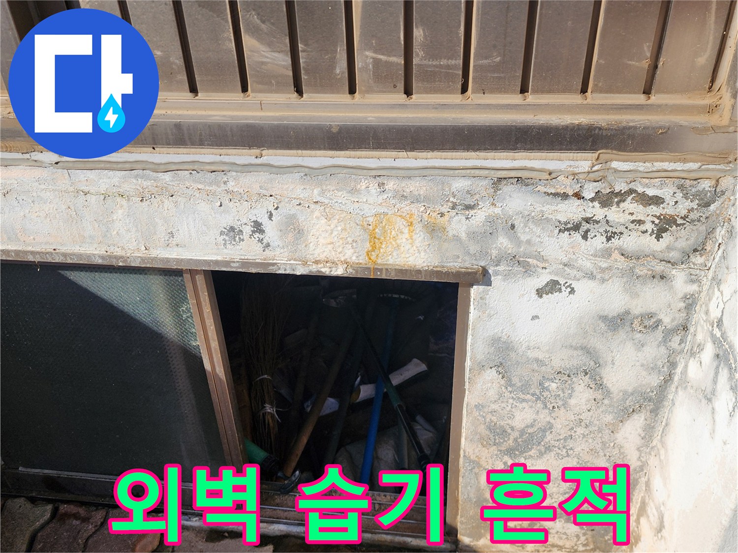 건물 마감재 아래쪽의 축축한 벽면과 변색된 부위